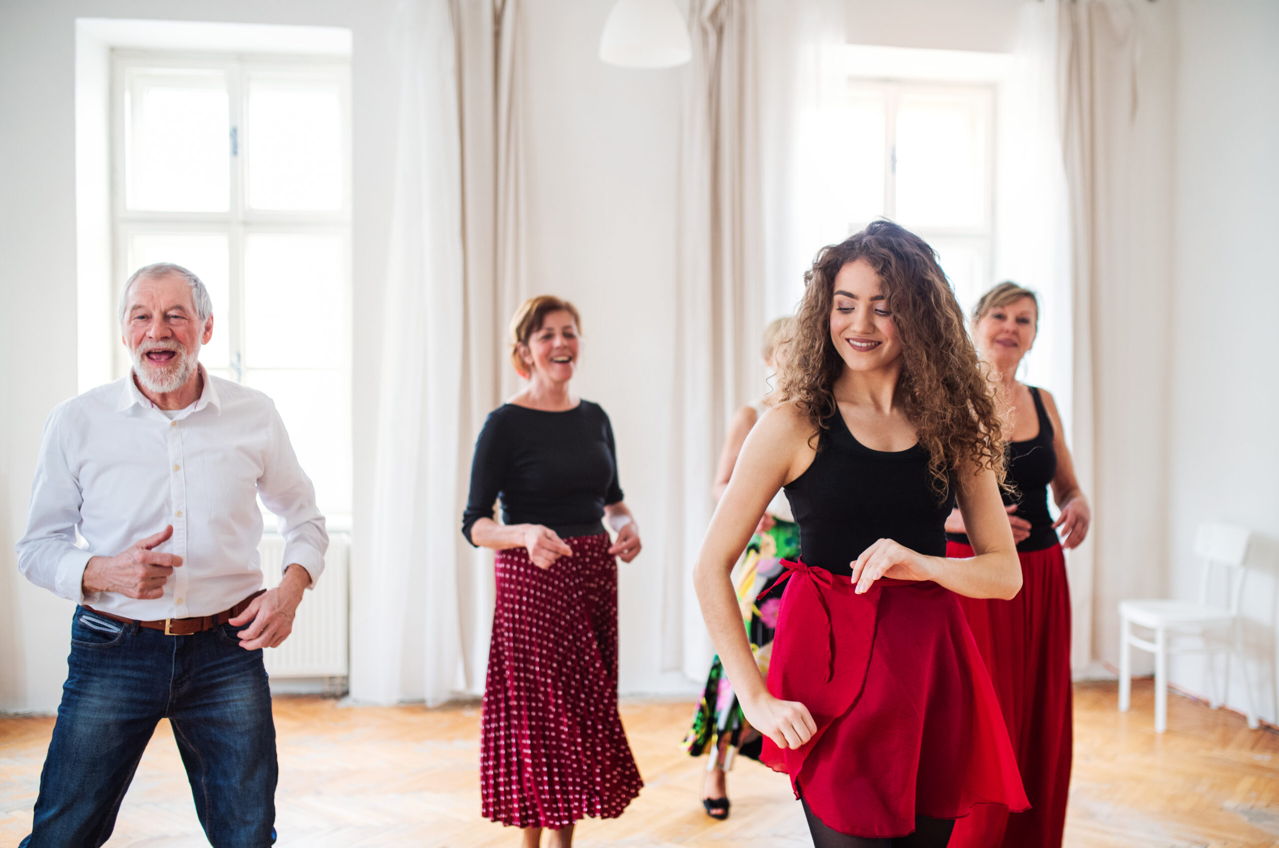 Group of people in dancing class with dance teacher.